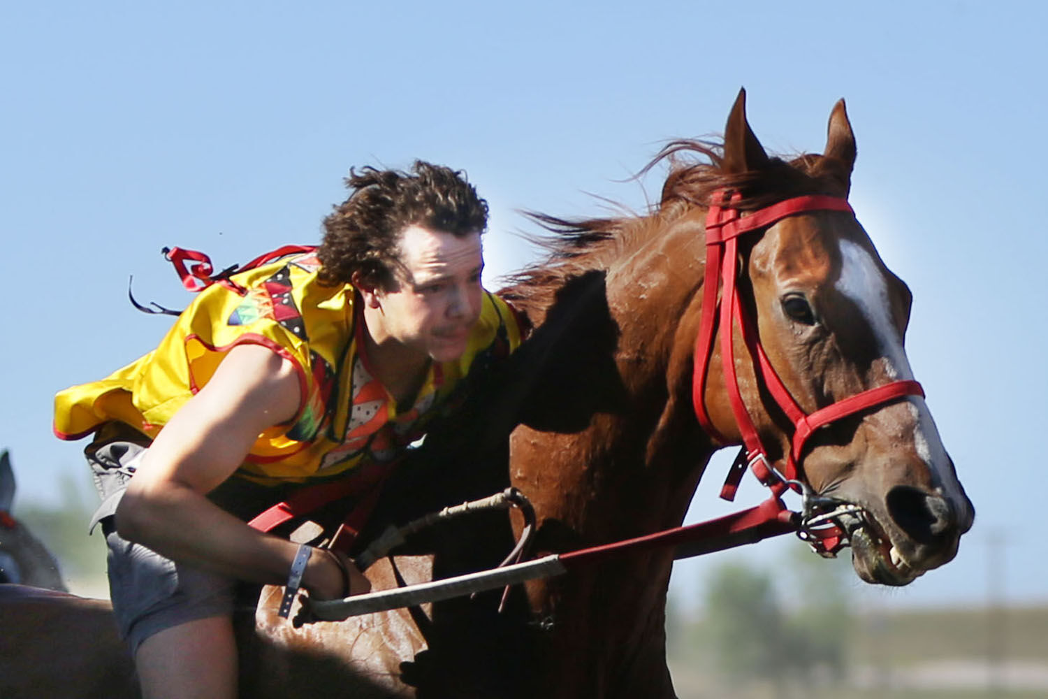 Cody Carlson pulls himself up and forward as his final relay horse